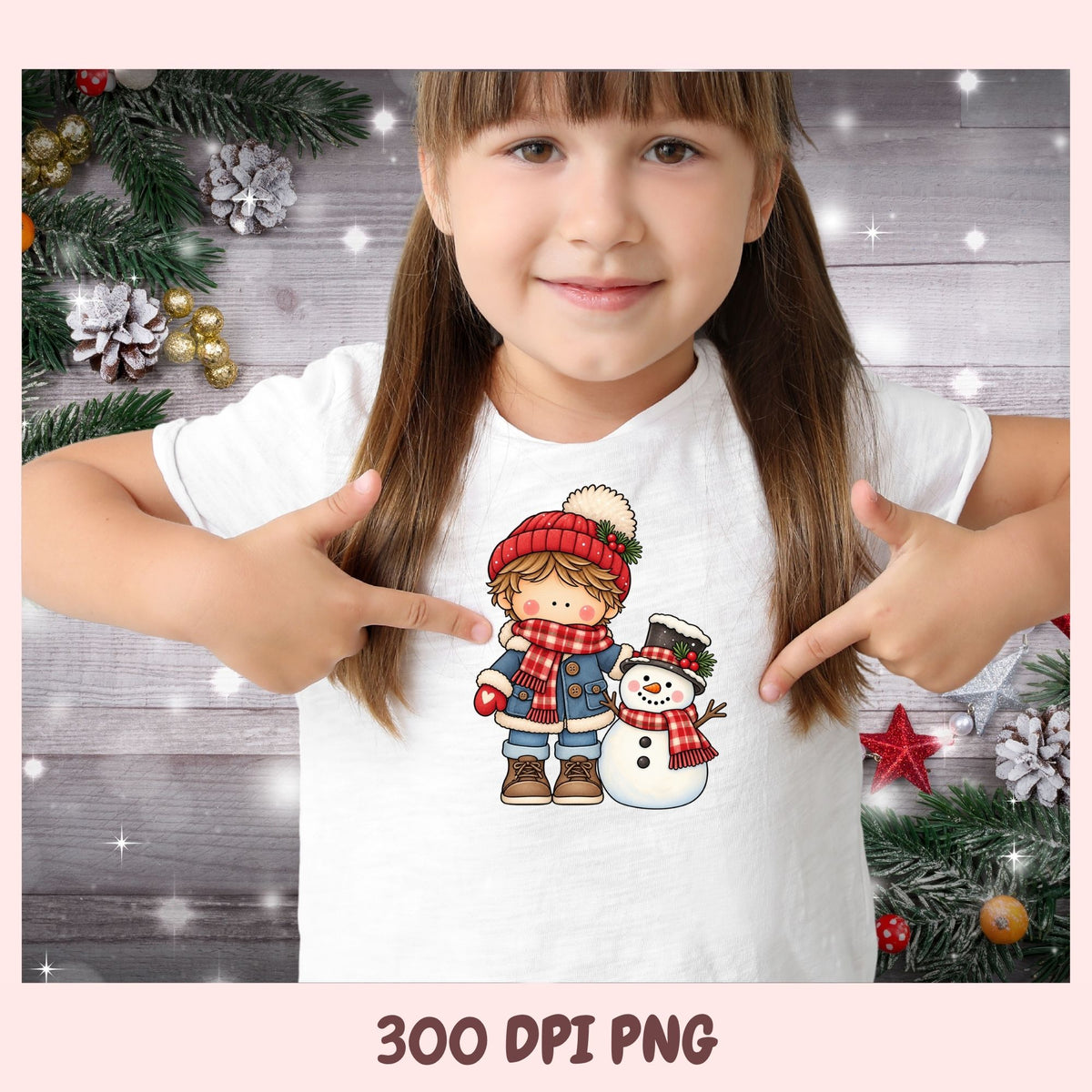 A young girl with brown hair in pigtails points at a graphic print on her white t-shirt. The graphic features a cute cartoon illustration of a girl in a red hat and scarf next to a snowman.