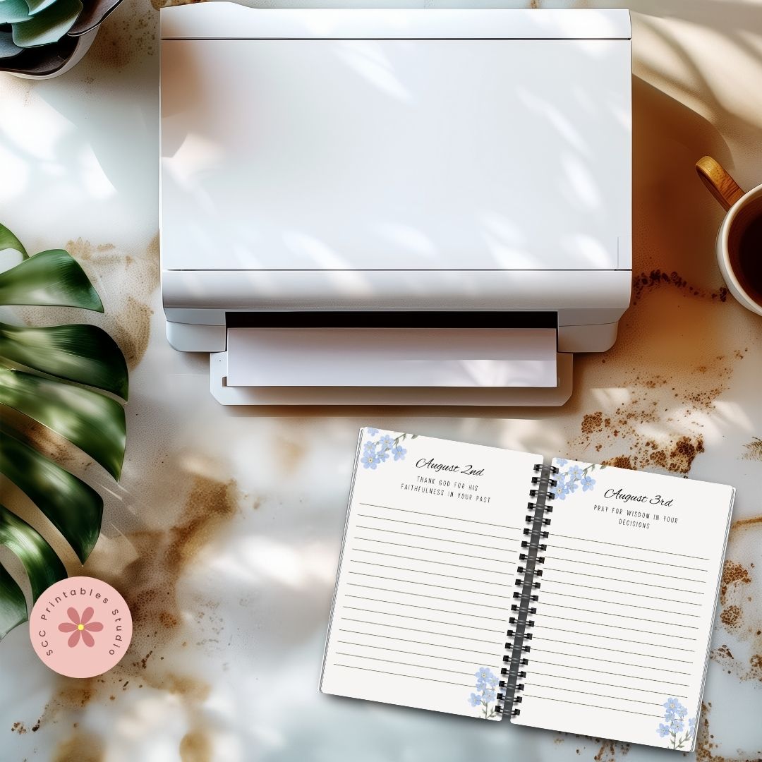 White printer on a marble surface with a planner and coffee cup