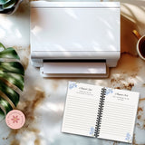 White printer on a marble surface with a planner and coffee cup