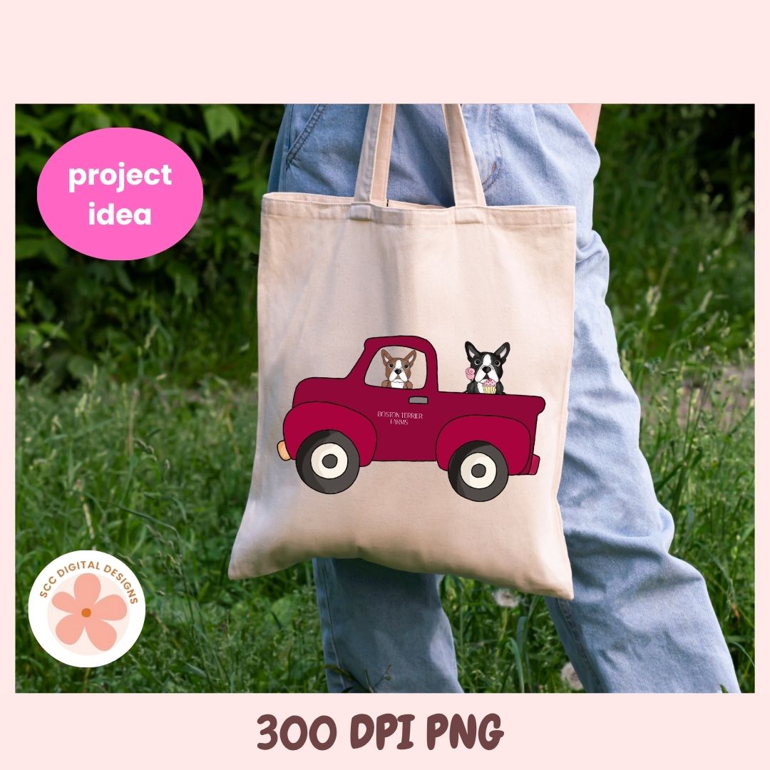 Tote bag with a red truck and dogs design held by a person outdoors.