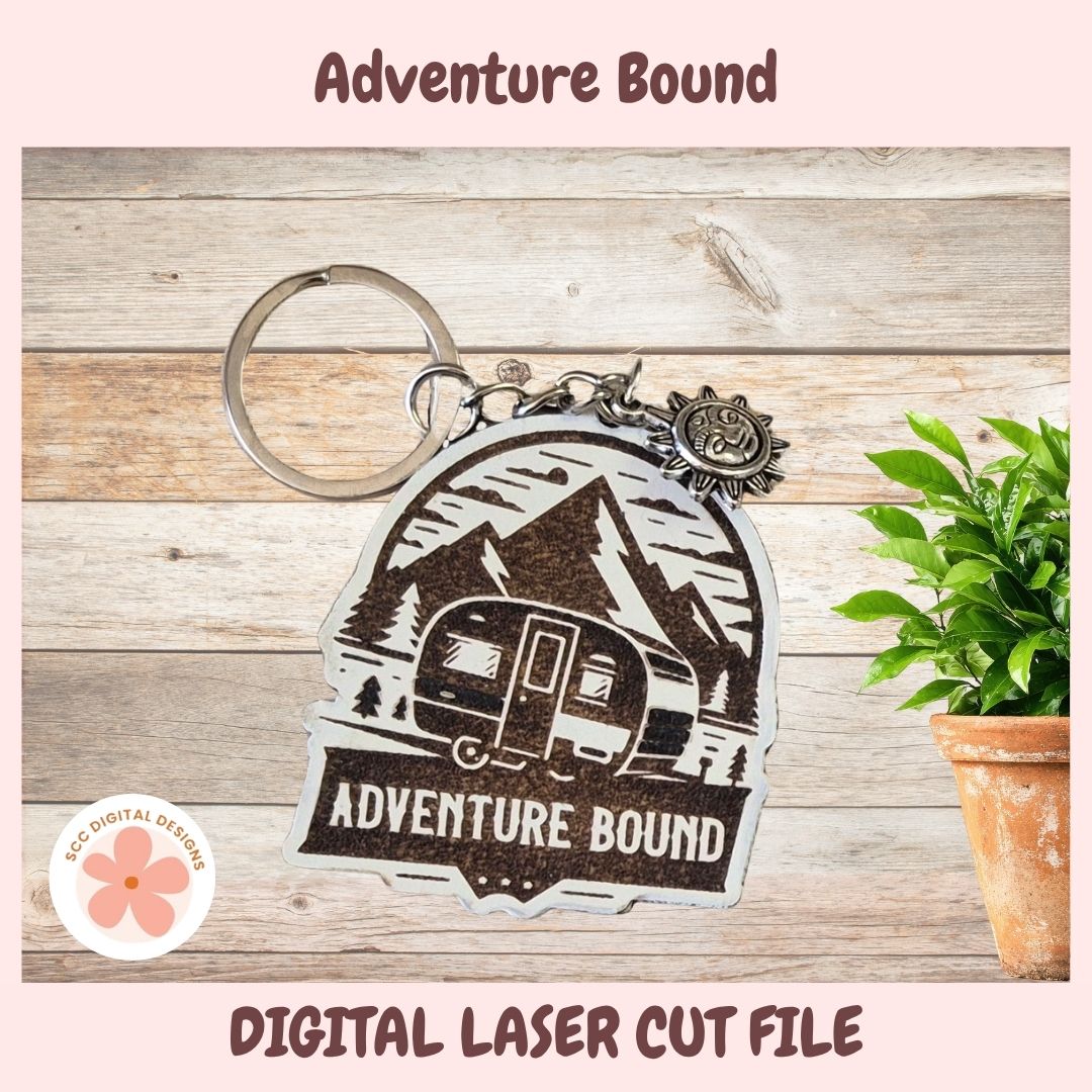 Keychain with 'Adventure Bound' design on a wooden surface with a plant.