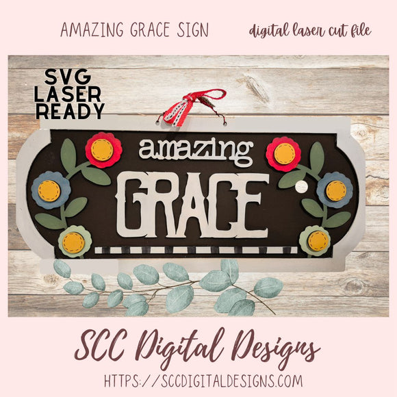 Decorative sign with 'amazing grace' text and floral designs on a wooden background, featuring SVG laser ready digital file by SCC Digital Designs.