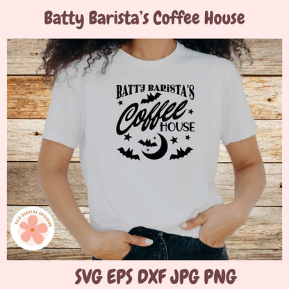 Person wearing a white t-shirt with 'Batty Barista's Coffee House' design on a wooden background