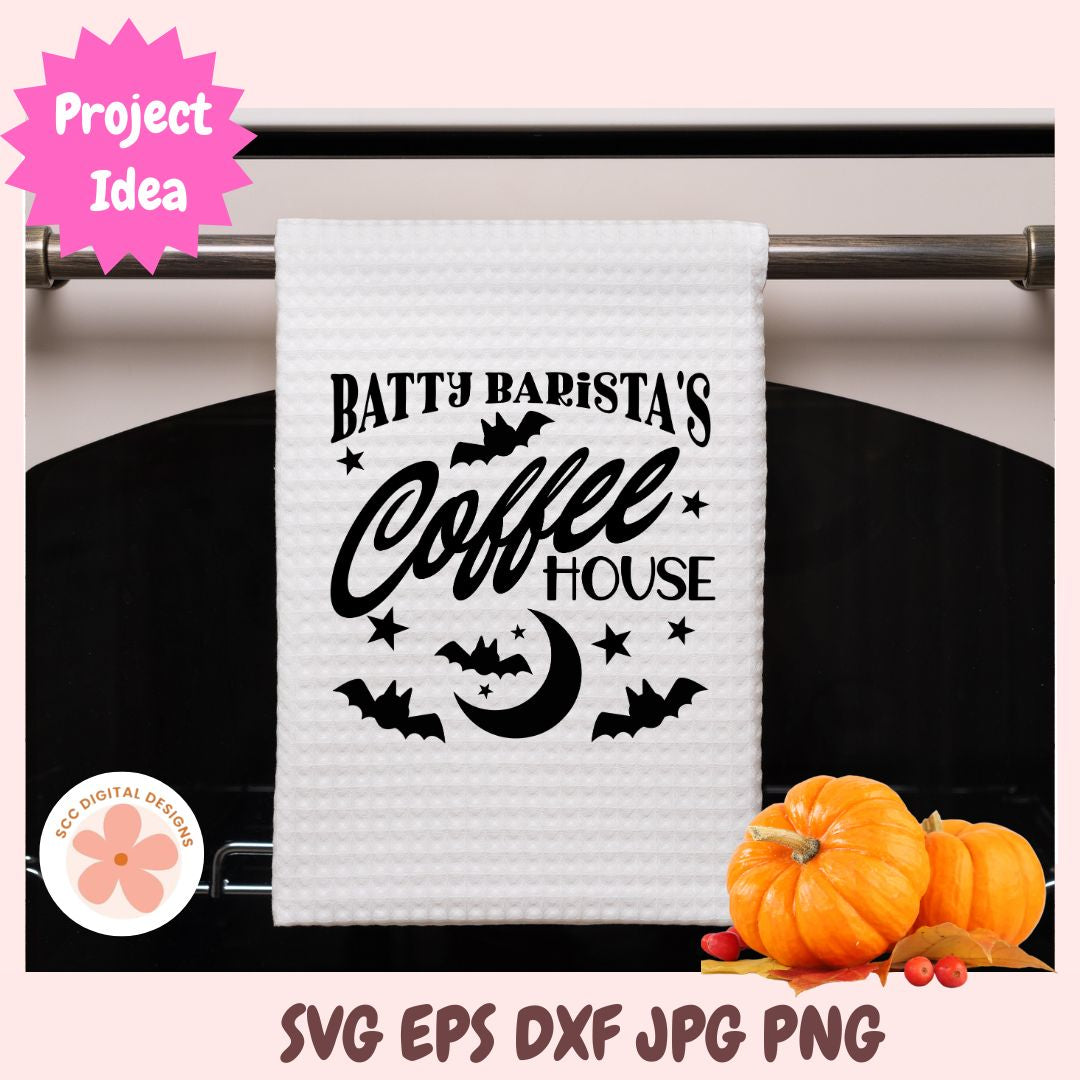 White towel with 'Batty Barista's Coffee House' text on a black background with pumpkins.