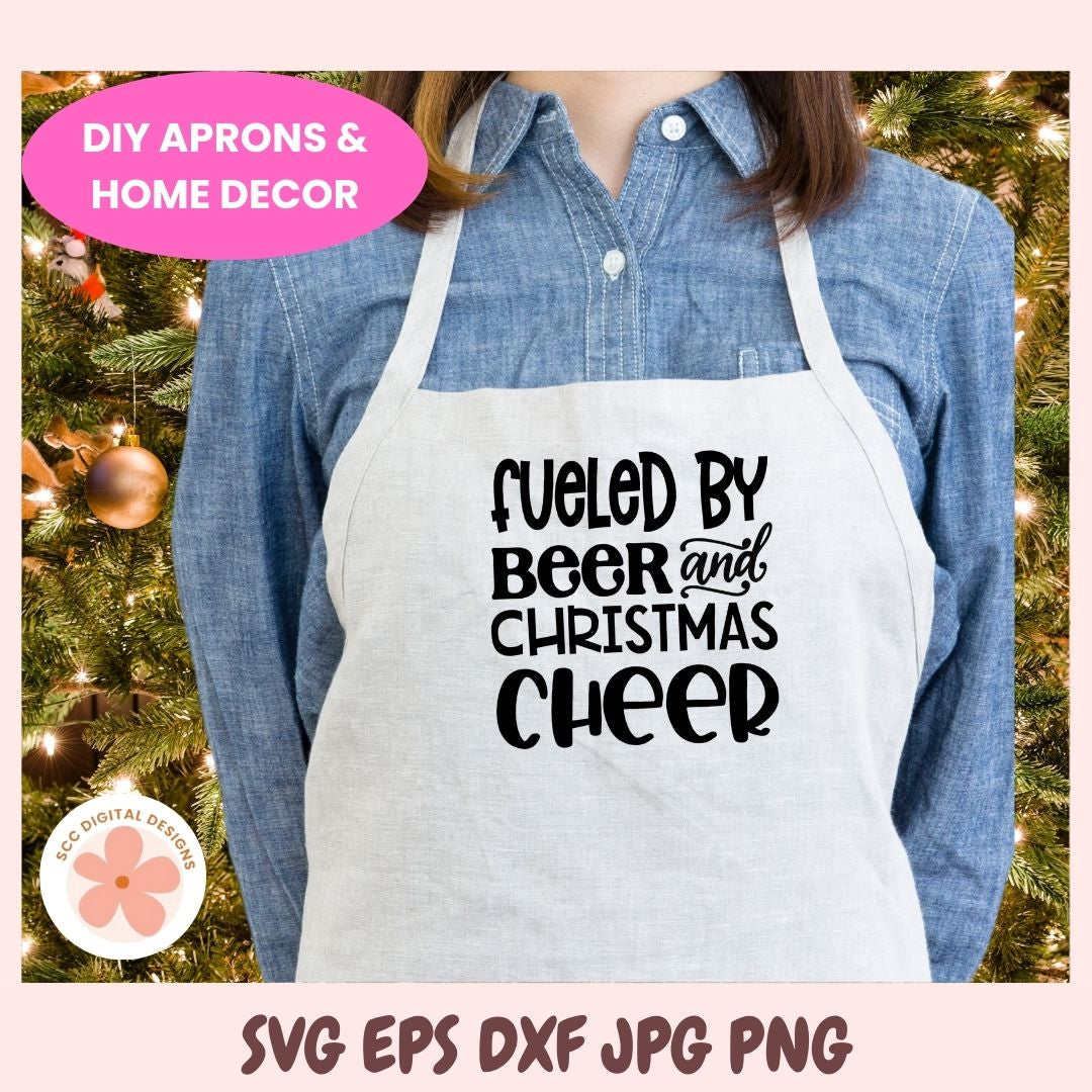 Person wearing a white apron with 'Fueled by Beer and Christmas Cheer' text, standing in front of a decorated Christmas tree.