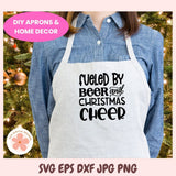 Person wearing a white apron with 'Fueled by Beer and Christmas Cheer' text, standing in front of a decorated Christmas tree.