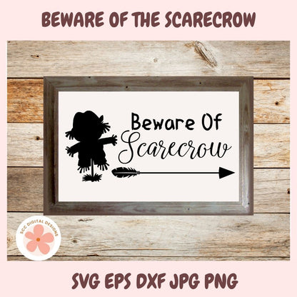 Framed sign with scarecrow silhouette and text 'Beware of Scarecrow' on a wooden background.