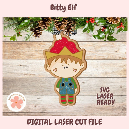 Digital preview of a Christmas elf cookie cutout design with pine branches and red berries at the top, a wood plank background, and text reading 'Bitty Elf', 'SVG LASER READY', and 'DIGITAL LASER CUT FILE'.