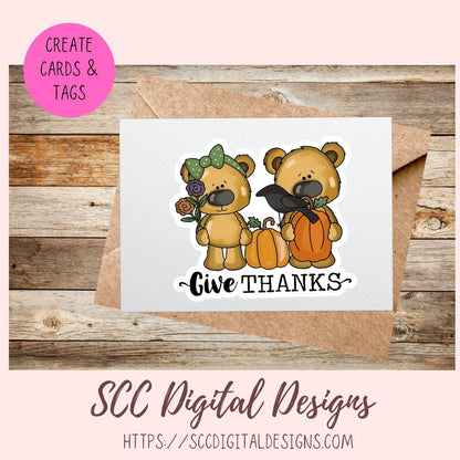 A fall-themed card design preview showing a white card with a die-cut sticker illustration of two teddy bears, pumpkins, a black bird, flowers, and the text 'Give THANKS'. The card is displayed over a kraft envelope on a rustic wood background, with a pink circle reading 'CREATE CARDS & TAGS' and 'SCC Digital Designs' branding at the bottom.
