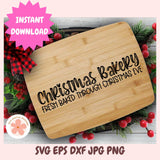 Wooden cutting board with Christmas bakery text surrounded by festive decorations.