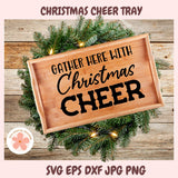 Wooden tray with 'Gather Here with Christmas Cheer' text, surrounded by Christmas decorations on a wooden surface.