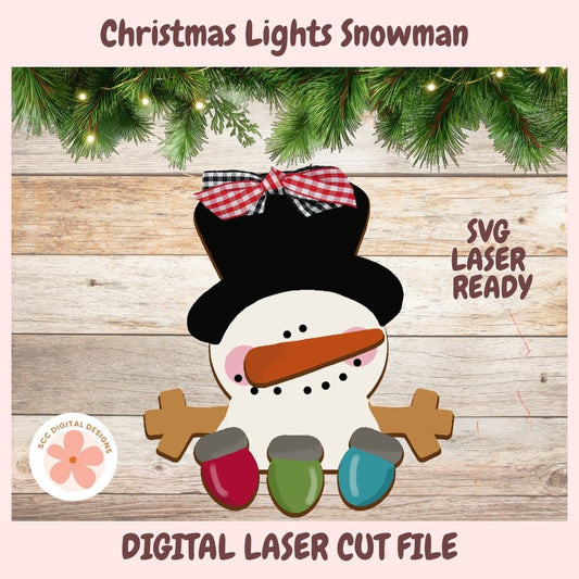 Digital design preview of a Christmas lights snowman with a black top hat, red gingham bow, orange carrot nose, and three colored Christmas lights, shown on a wood plank background with pine branches and text reading 'Christmas Lights Snowman', 'SVG LASER READY', and 'DIGITAL LASER CUT FILE'.