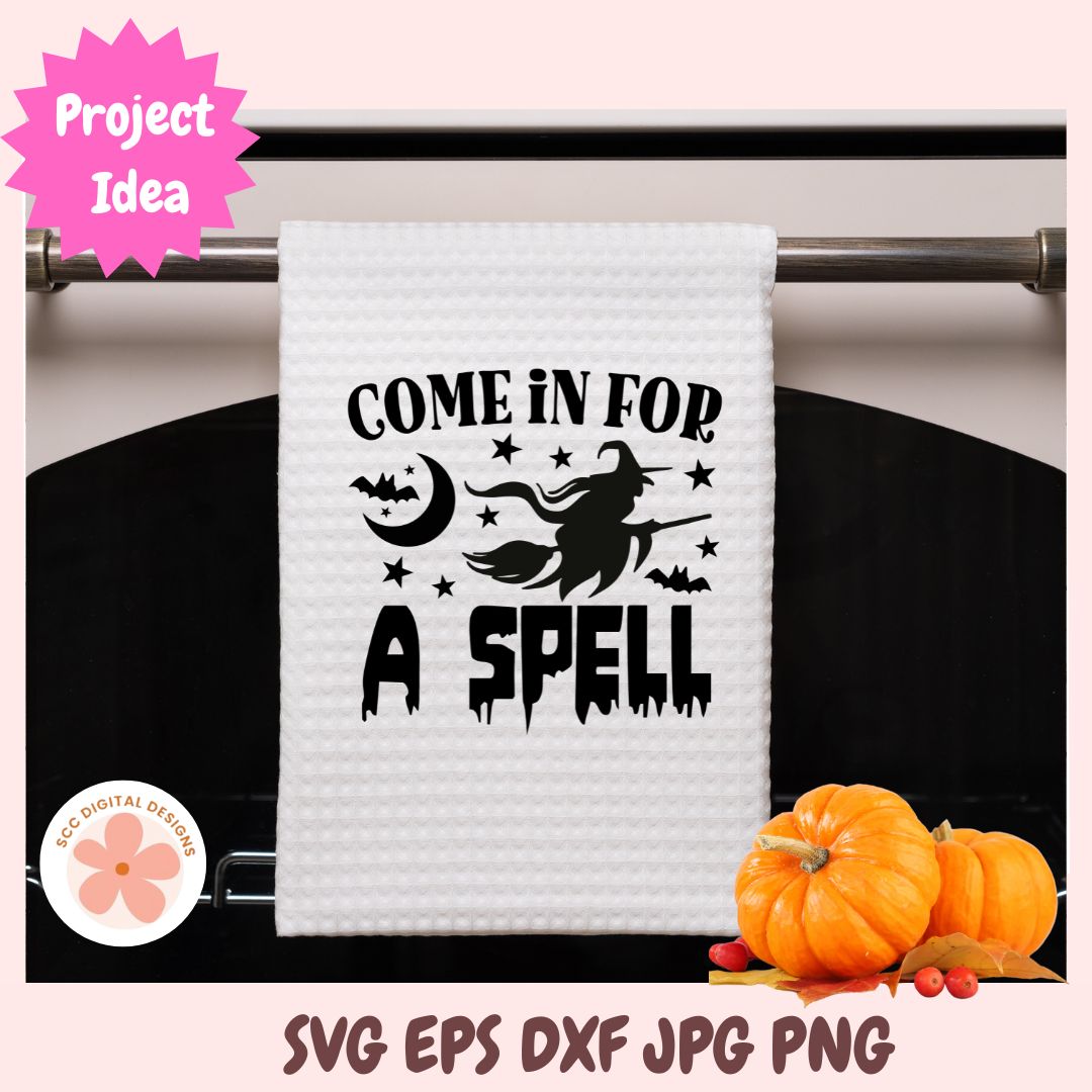 White towel with Halloween-themed text and graphics on a rack, with pumpkins in the background.