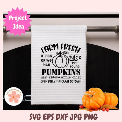 White towel with black text and pumpkin graphic on a rack, with pumpkins and a pink 'Project Idea' label in the background.