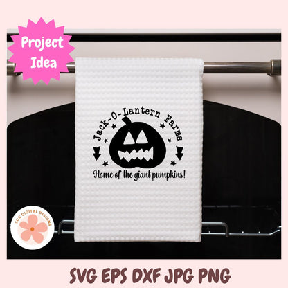White towel with Halloween design hanging on a rack, featuring 'Jack-O-Lantern Farms' text and pumpkin graphic.