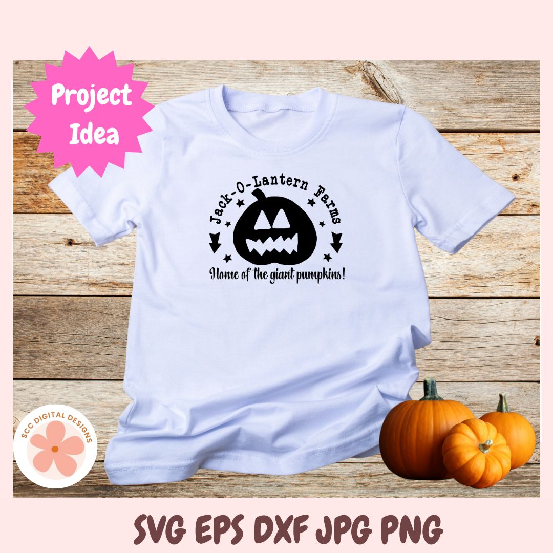 White t-shirt with Halloween design on a wooden surface with pumpkins.