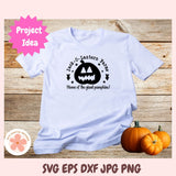 White t-shirt with Halloween design on a wooden surface with pumpkins.