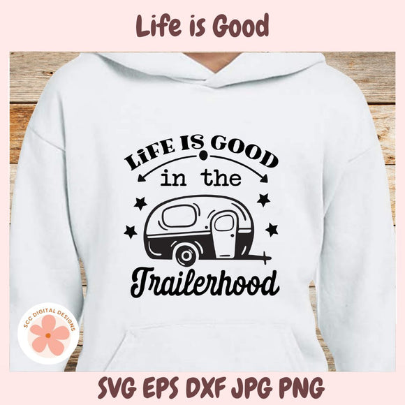 White hoodie with 'Life is Good in the Trailerhood' text and camper graphic on a wooden surface.