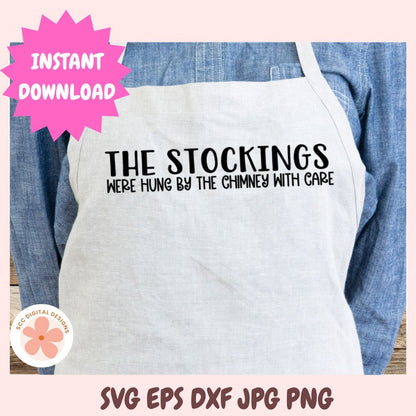 White apron with text 'THE STOCKINGS WERE HUNG BY THE CHIMNEY WITH CARE' on a pink background