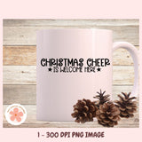 Mug with 'Christmas Cheer is Welcome Here' text and pinecones on a wooden background