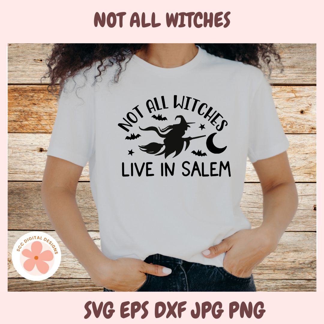 Person wearing a white t-shirt with 'Not All Witches Live in Salem' design on a wooden background
