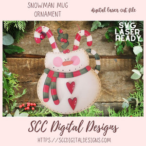 Snowman mug ornament with candy canes and plaid scarf on a wooden background
