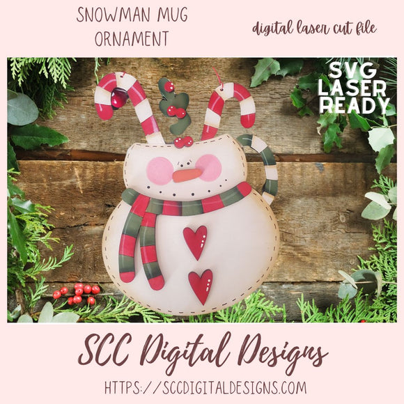 Snowman mug ornament with candy canes and plaid scarf on a wooden background