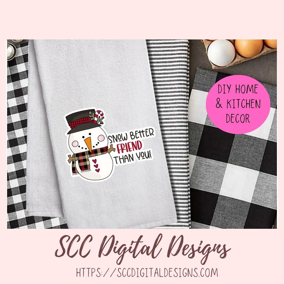 A digital design mockup for a kitchen towel featuring a snowman wearing a black and red plaid top hat and scarf, with the text 'SNOWY BETTER FRIEND THAN YOU!' on a light gray towel. The image includes a pink circular badge reading 'DIY HOME & KITCHEN DECOR' and a bottom banner for 'SCC Digital Designs'.
