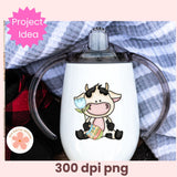 White tumbler with a cow design and clear lid on a plaid fabric background