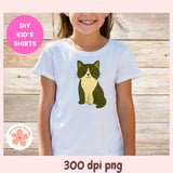 Child wearing a white t-shirt with a green cat graphic on a wooden background