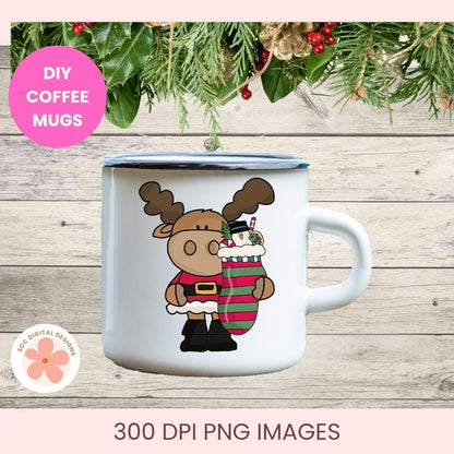 A white enamel-style coffee mug with a blue rim, featuring a cartoon moose holding a striped stocking. The mug is shown on a rustic wood background with holiday greenery and a pink 'DIY COFFEE MUGS' badge.