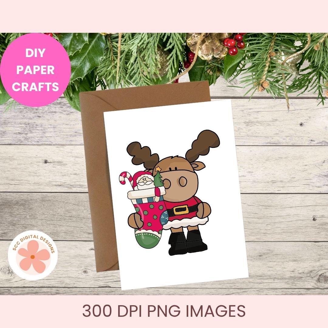 A Christmas-themed greeting card featuring a cartoon reindeer holding a red stocking with a candy cane, displayed with a brown envelope on a rustic wood background with holiday greenery. Pink banner text reads 'DIY PAPER CRAFTS' and '300 DPI PNG IMAGES'.