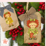Two decorative paper bags with cartoon characters on a Christmas-themed background with berries and greenery.