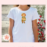 White t-shirt with a annie rag doll design on a wooden background