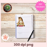 Notebook with a sticker of a horse eating pizza on a wooden surface with a pen and cactus.