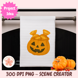 White towel with pumpkin design hanging on a rack, surrounded by small pumpkins.