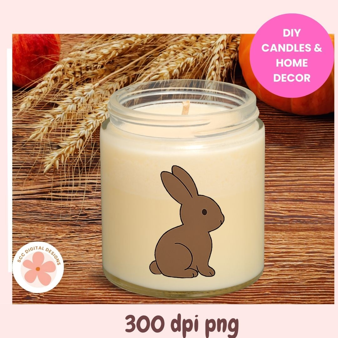 Candle with a rabbit design on a wooden surface with wheat and pumpkins.