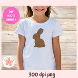 Child wearing a white t-shirt with a brown rabbit graphic on a wooden background