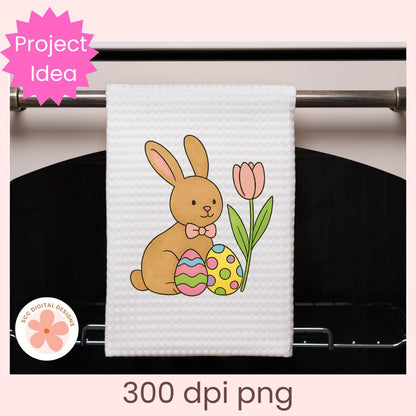 White towel with Easter design hanging on a rack, featuring a bunny and egg.