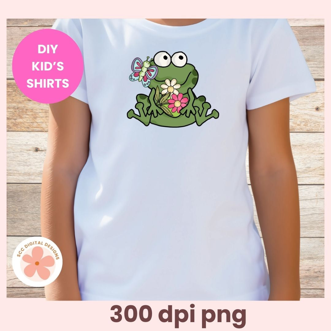 White t-shirt with a green frog graphic on a wooden background, labeled 'DIY Kids' Shirts'.