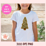Child wearing a white t-shirt with a Christmas tree design on a wooden background