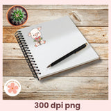 Notebook with a pig illustration, pen, and small plant on a wooden surface