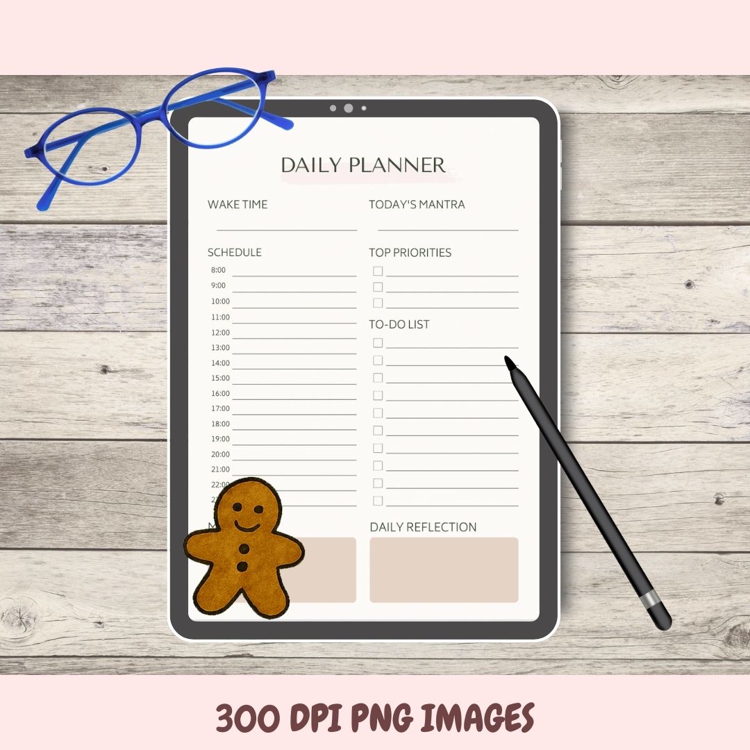 Daily planner on a tablet with a gingerbread man sticker, glasses, and a pen on a wooden surface.