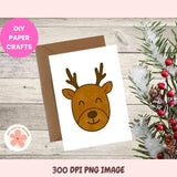 Card with reindeer design on a wooden surface with Christmas decorations