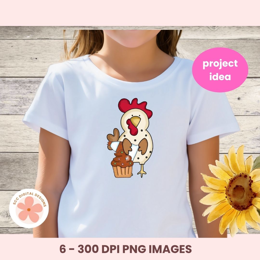 White t-shirt with a cartoon rooster holding a cupcake design, on a wooden background with a sunflower.