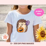 White t-shirt with a hedgehog design holding a pumpkin and a lollipop, on a wooden background.
