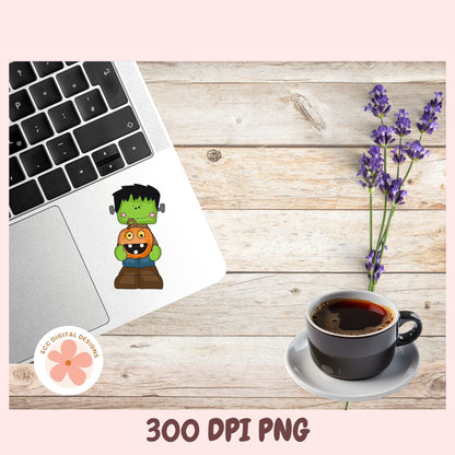 A flat-lay mockup showing a cartoon Frankenstein's monster sticker applied to a silver laptop, alongside a cup of coffee, lavender flowers, and a wooden tabletop. The image has a pink border with text reading '300 DPI PNG' and a circular 'SEC DIGITAL DESIGNS' logo.
