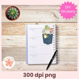 Notebook with a decorative sticker of a gnome in a pocket on a wooden surface, with a cactus plant and pen.