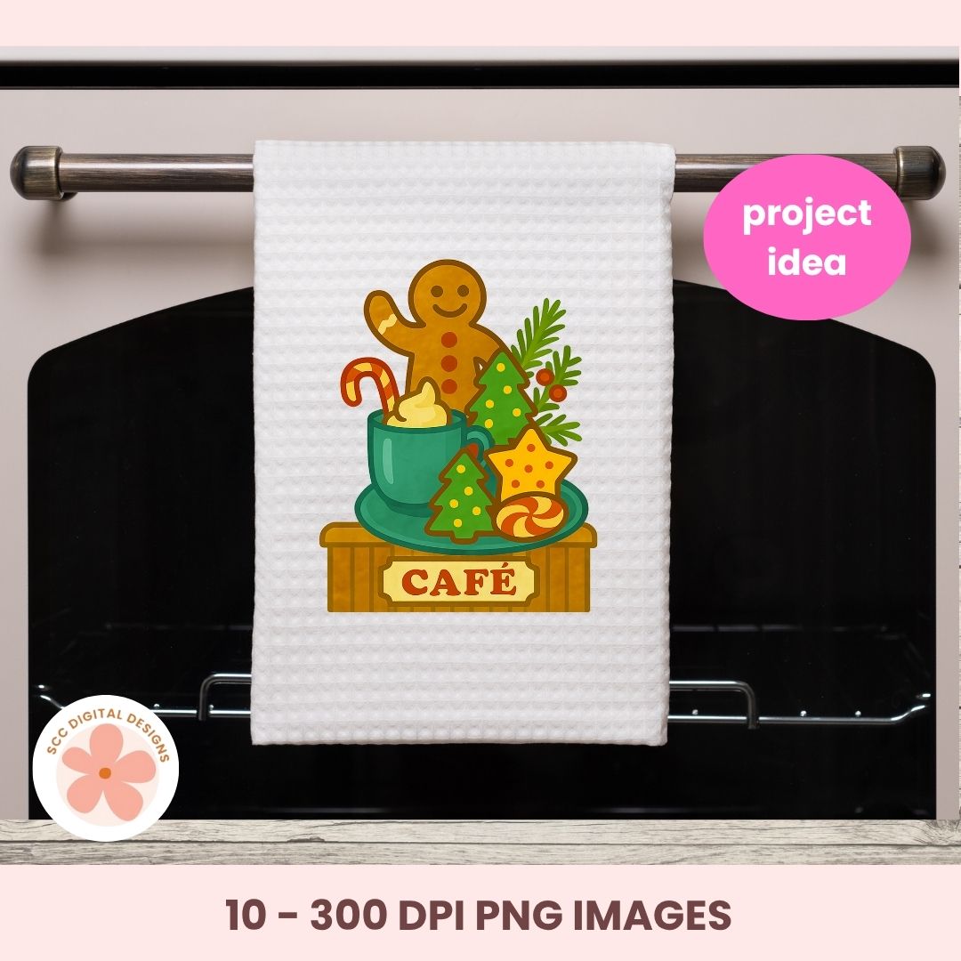 A white kitchen towel with a festive gingerbread-themed 'Café' print hanging on a metal oven rack. The print features a gingerbread man, a mug, holiday trees, and a star with the word 'CAFÉ'.