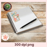 Notebook with a pen and a sticker of a dog on a wooden surface, featuring a small plant.
